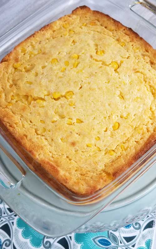 A top down view of a Sweet Creamed Corn Casserole in a square, glass baking dish.