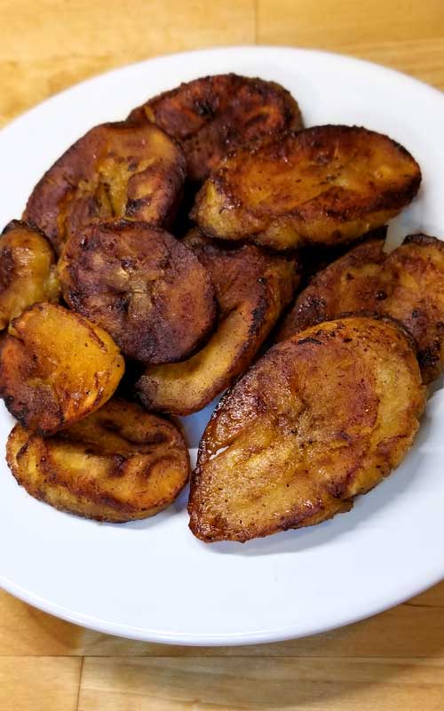 Prepared Sweet Fried Plantains piled up on a small white plate.