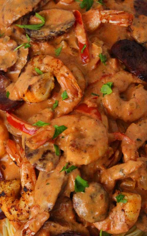 Close up view of a prepared Creamy Cajun Shrimp and Sausage Pasta highlighting the cream sauce.