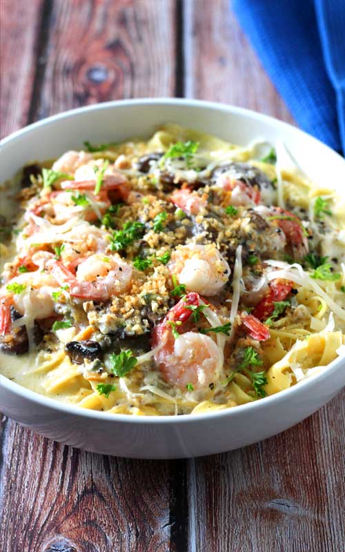 When shrimp, crab, clams, and mushrooms come together in a luscious creamy, cheesy garlic sauce over fresh pasta, you get this delectable Seafood Alfredo Fettuccine!