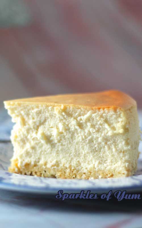 Image highlighting the texture of a piece of New York Cheesecake. The  photograph is taken from the side.