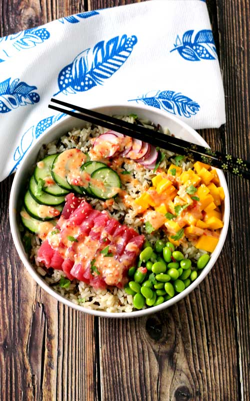 An absolutely divine Hawaiian Tuna Poke Bowl with fresh ahi tuna, bright crisp radish, cucumber, edamame, and sweet mango over wild rice with a drizzle of sweet chili aioli? Yes, please!