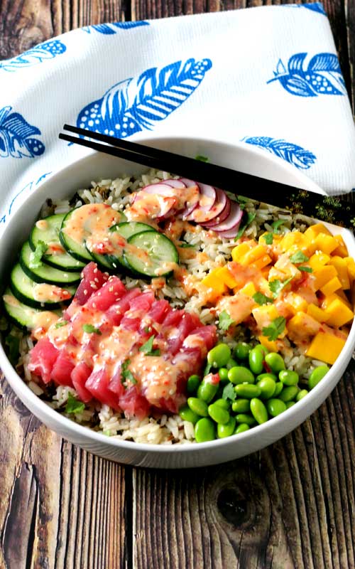 An absolutely divine Hawaiian Tuna Poke Bowl with fresh ahi tuna, bright crisp radish, cucumber, edamame, and sweet mango over wild rice with a drizzle of sweet chili aioli? Yes, please!