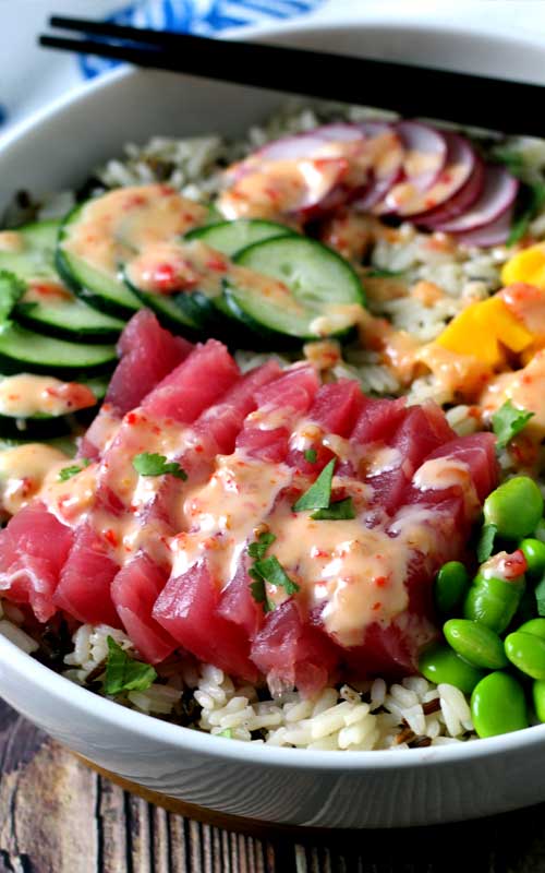 An absolutely divine Hawaiian Tuna Poke Bowl with fresh ahi tuna, bright crisp radish, cucumber, edamame, and sweet mango over wild rice with a drizzle of sweet chili aioli? Yes, please!