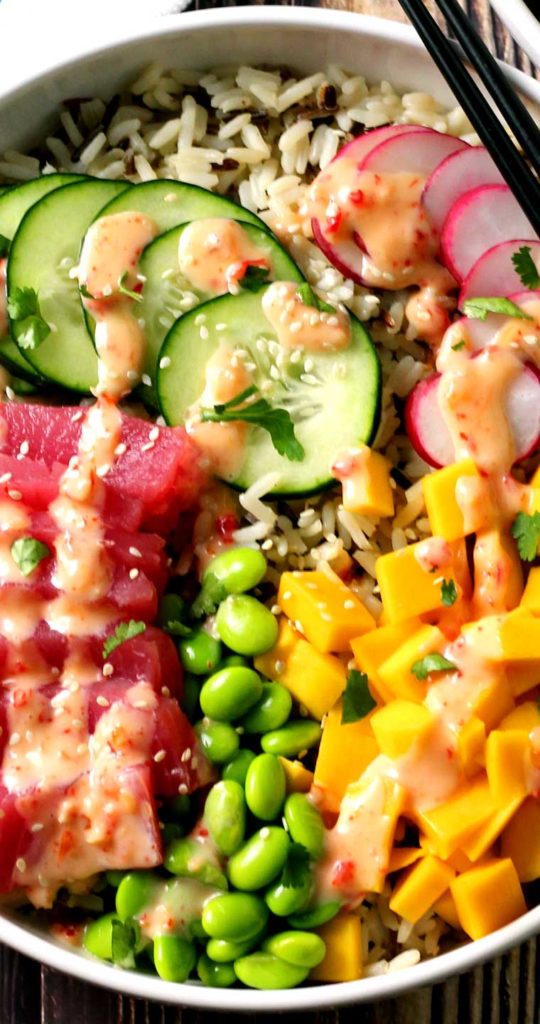 An absolutely divine Hawaiian Tuna Poke Bowl with fresh ahi tuna, bright crisp radish, cucumber, edamame, and sweet mango over wild rice with a drizzle of sweet chili aioli? Yes, please!