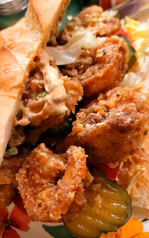  A close up view of a Shrimp Po'Boy with Rémoulade Sauce. The shrimp on this sandwich has been deep fried.